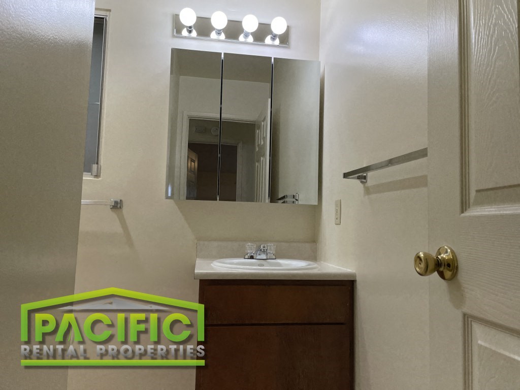 a bathroom with a sink and a mirror and a door