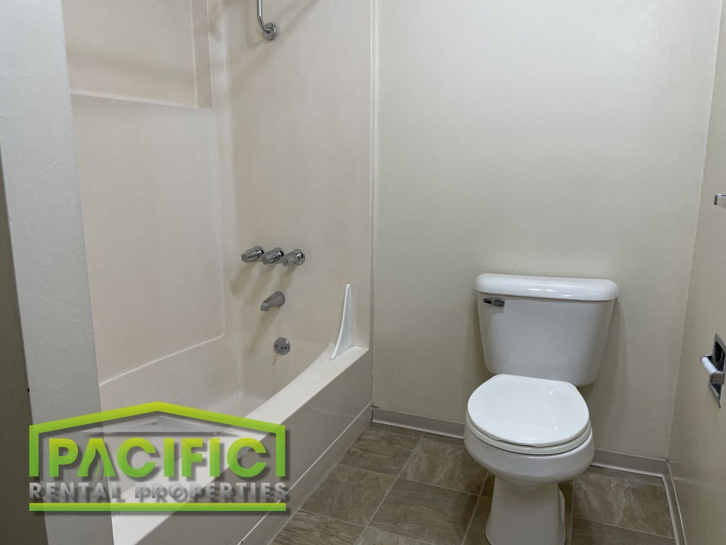 a bathroom with a toilet and a bath tub