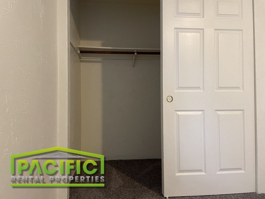 the closet in a small room with a white door