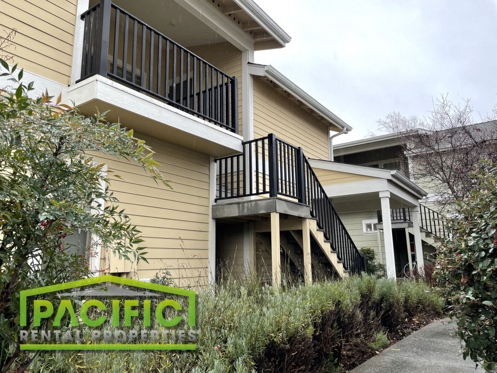 a house with two balconies and a sidewalk