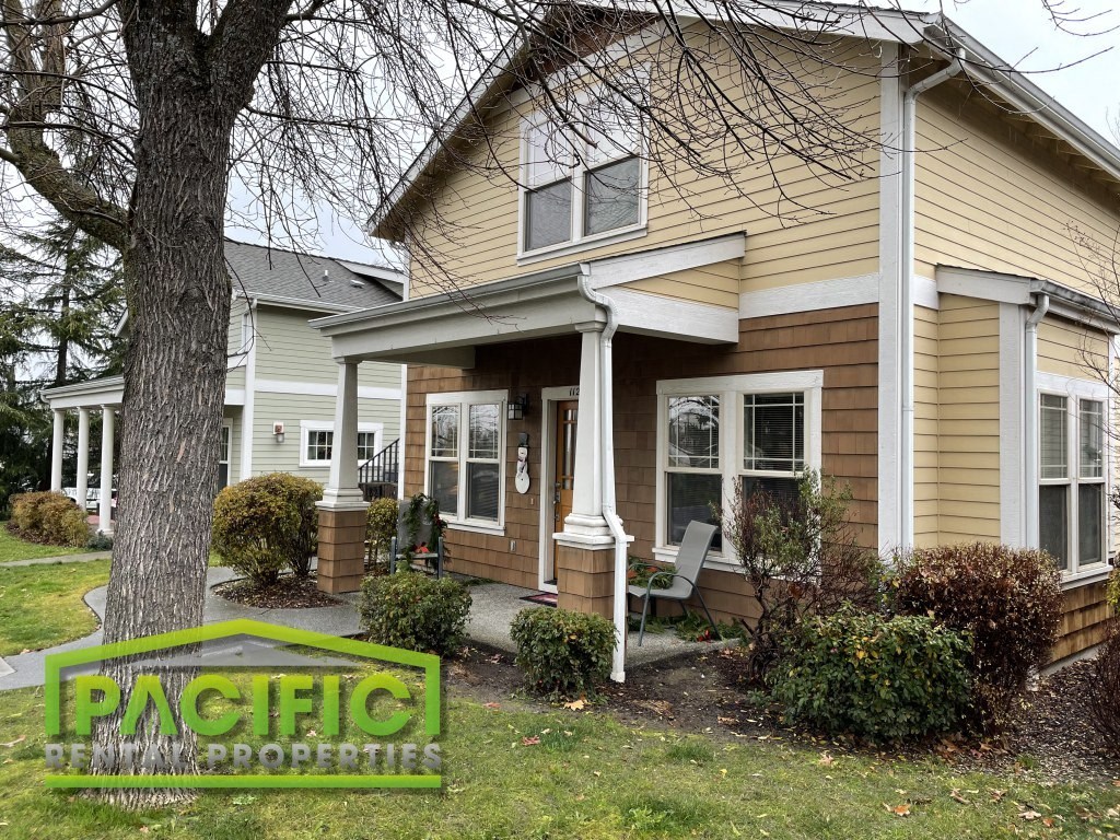 a house with a porch and a tree in front of it