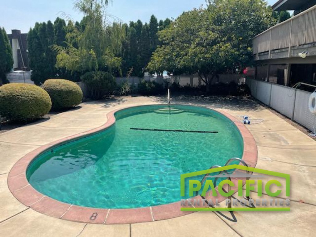 a swimming pool in a backyard next to a building