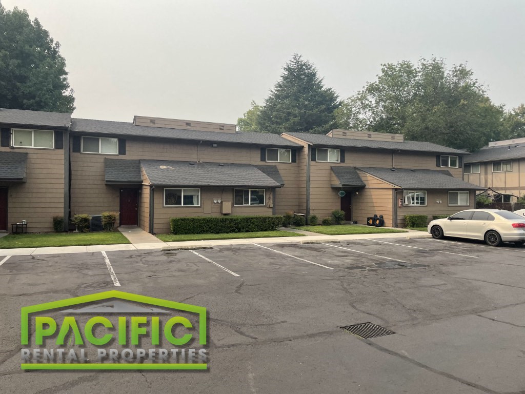 an empty parking lot in front of an apartment building