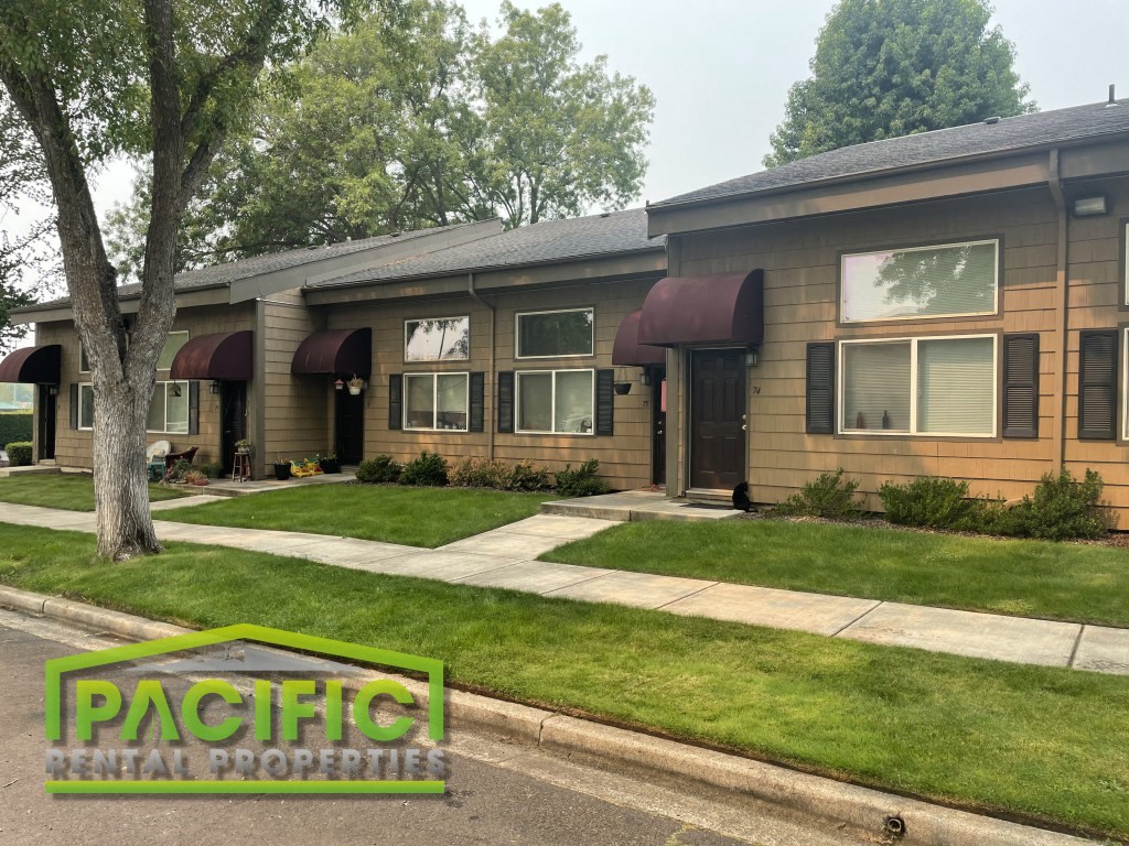 a home with a lawn and a sidewalk in front of it