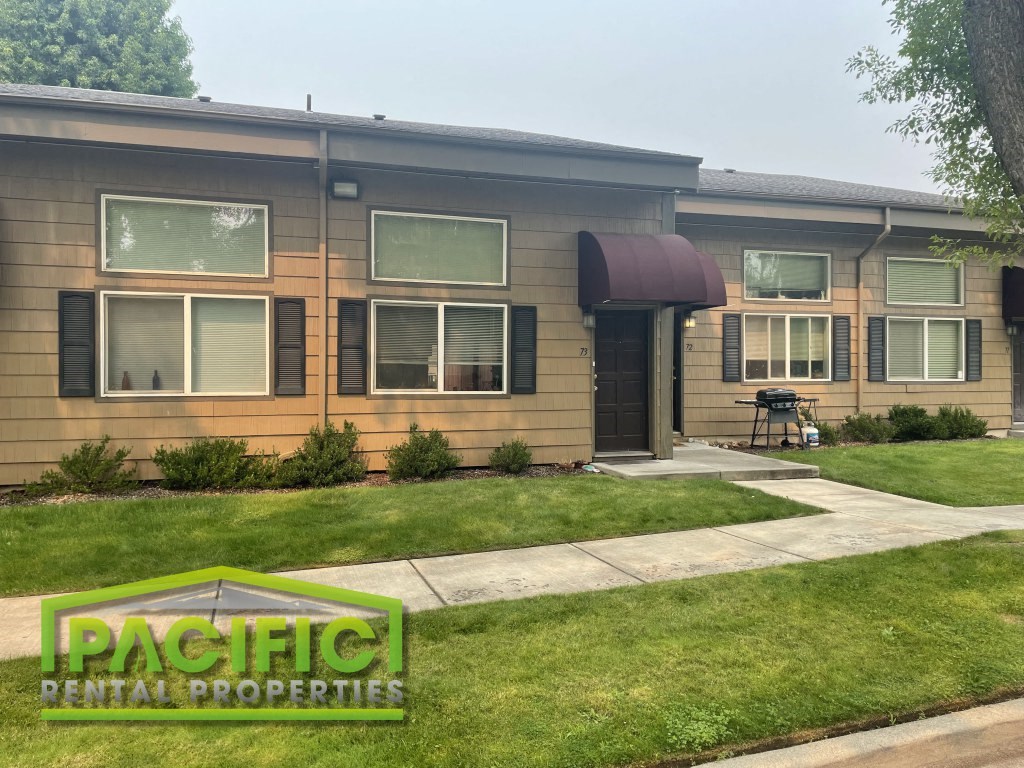 a house with a lawn and a sidewalk in front of it