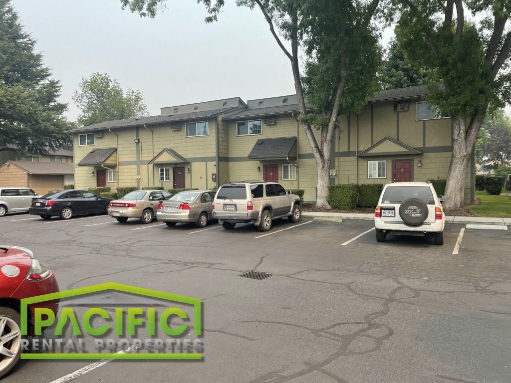 a parking lot with cars in front of a building
