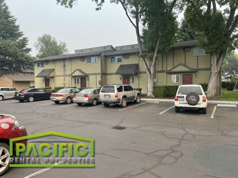 a parking lot with cars in front of a building