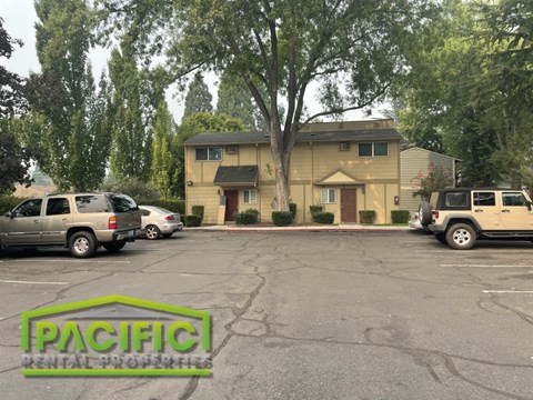 a parking lot with cars in front of a house