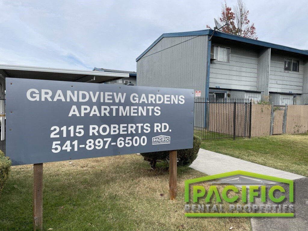 A sign for Grandview Gardens Apartments is displayed in front of a building.