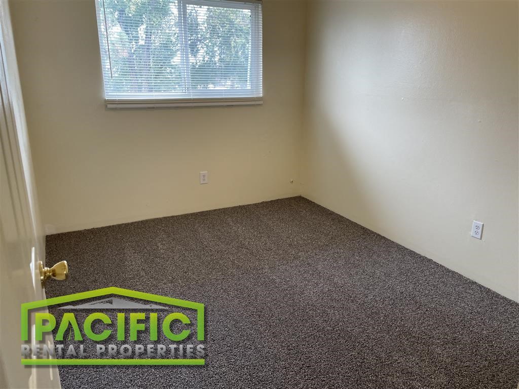 an empty room with a carpeted floor and a window