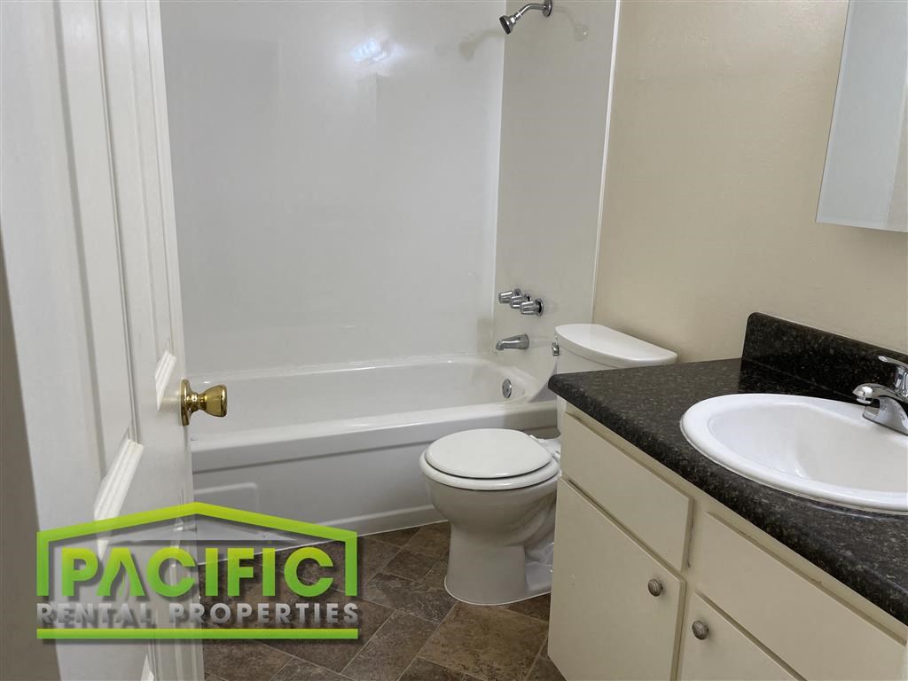 a bathroom with a toilet and a tub and a sink