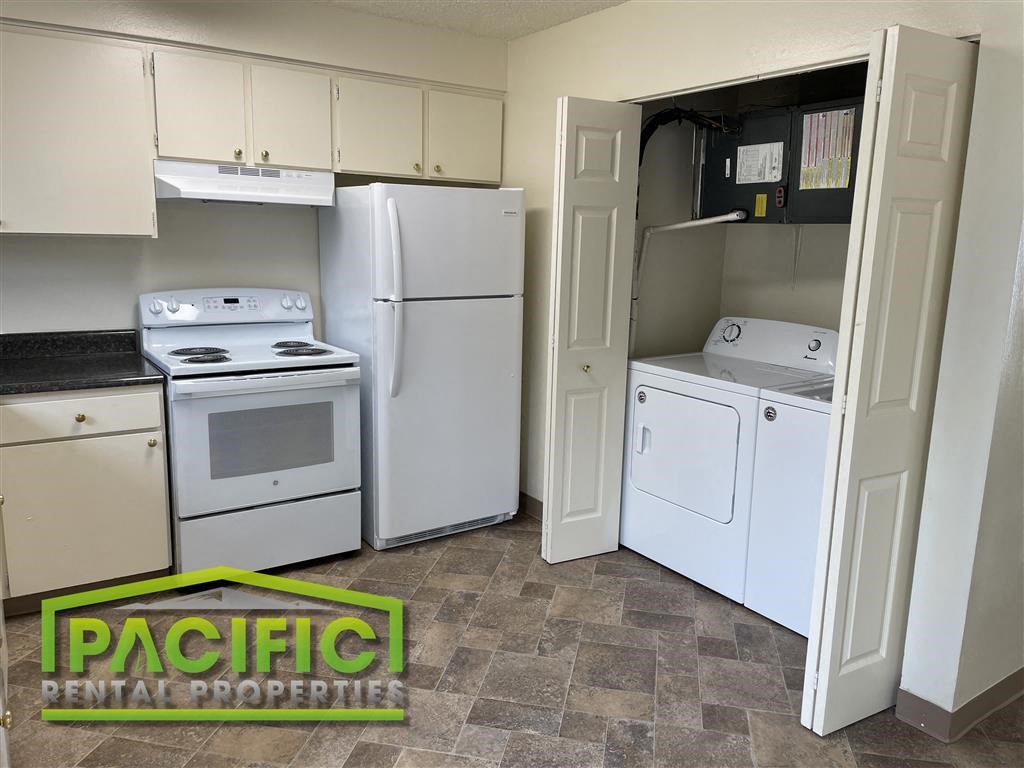 a kitchen with white appliances and white cabinets