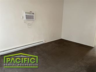 a room with a carpet and an air conditioner on the wall