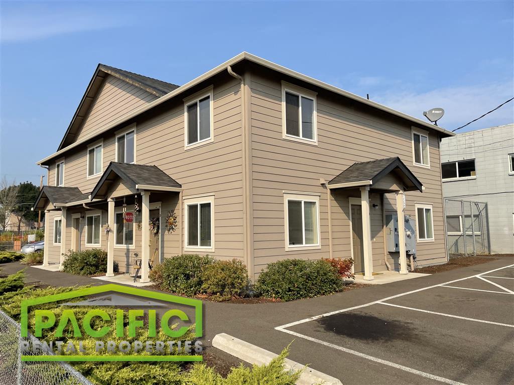 a tan and brown house with a parking lot