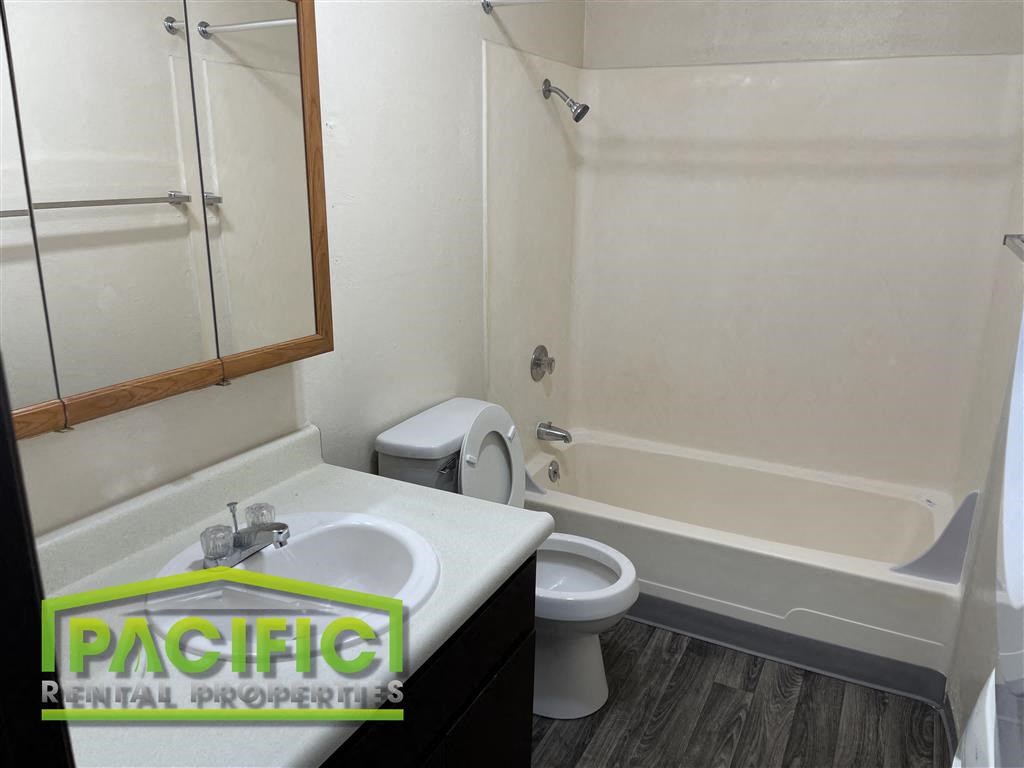 a bathroom with a toilet and a sink and a bath tub