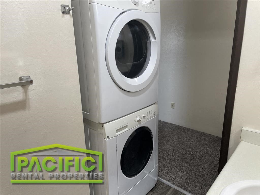 a washing machine in a bathroom next to a toilet