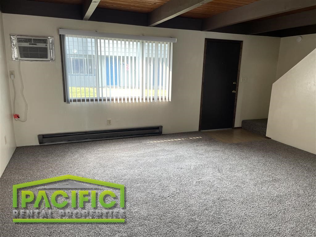 an empty room with a carpeted floor and a window