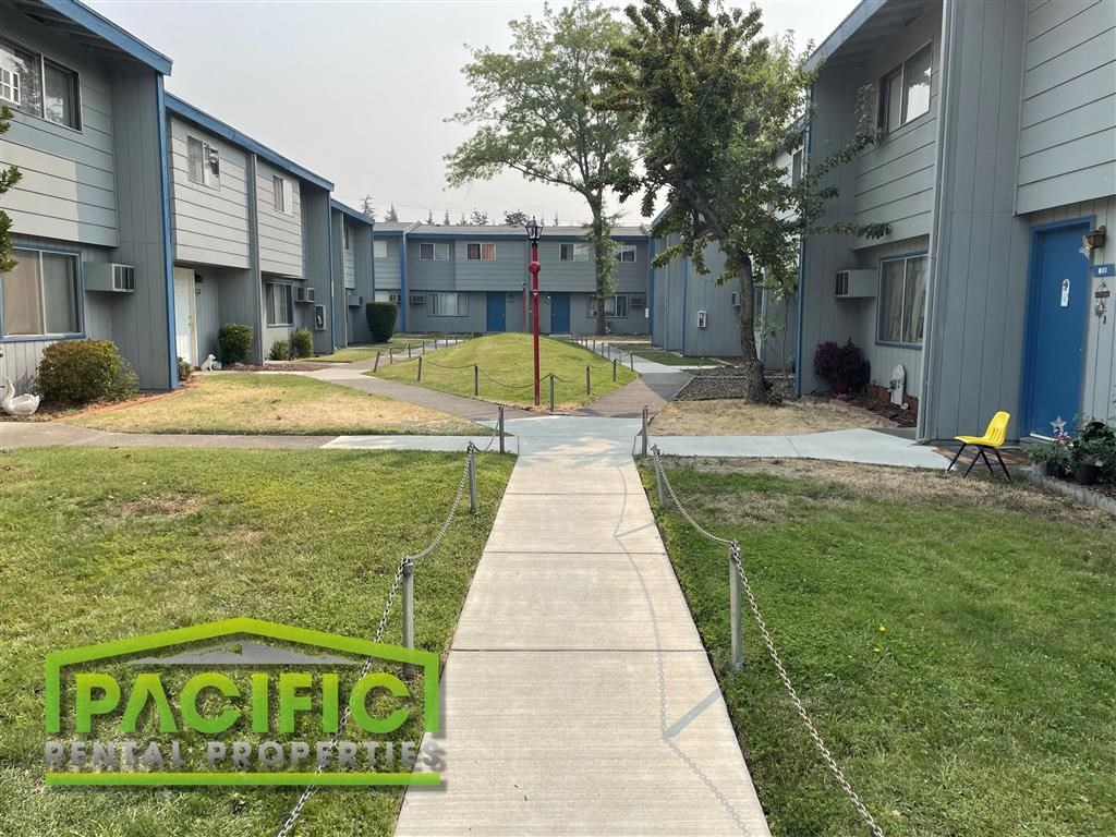 an empty sidewalk in front of an apartment building