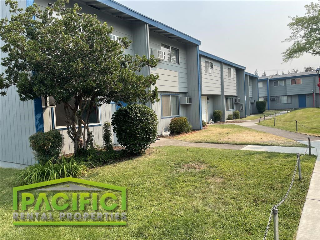 a row of houses with grass and trees in front of them
