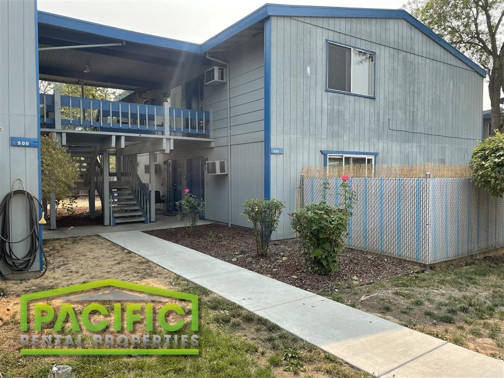 a blue house with a sidewalk in front of it