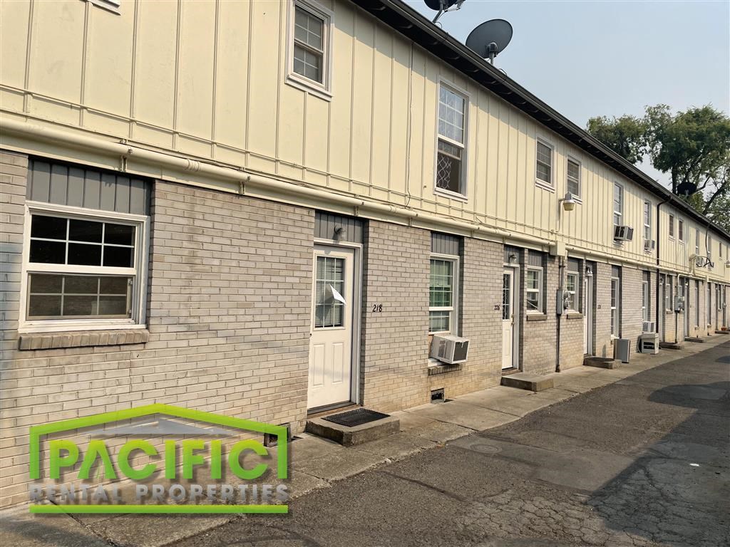 an old brick building with a pacific rental properties sign
