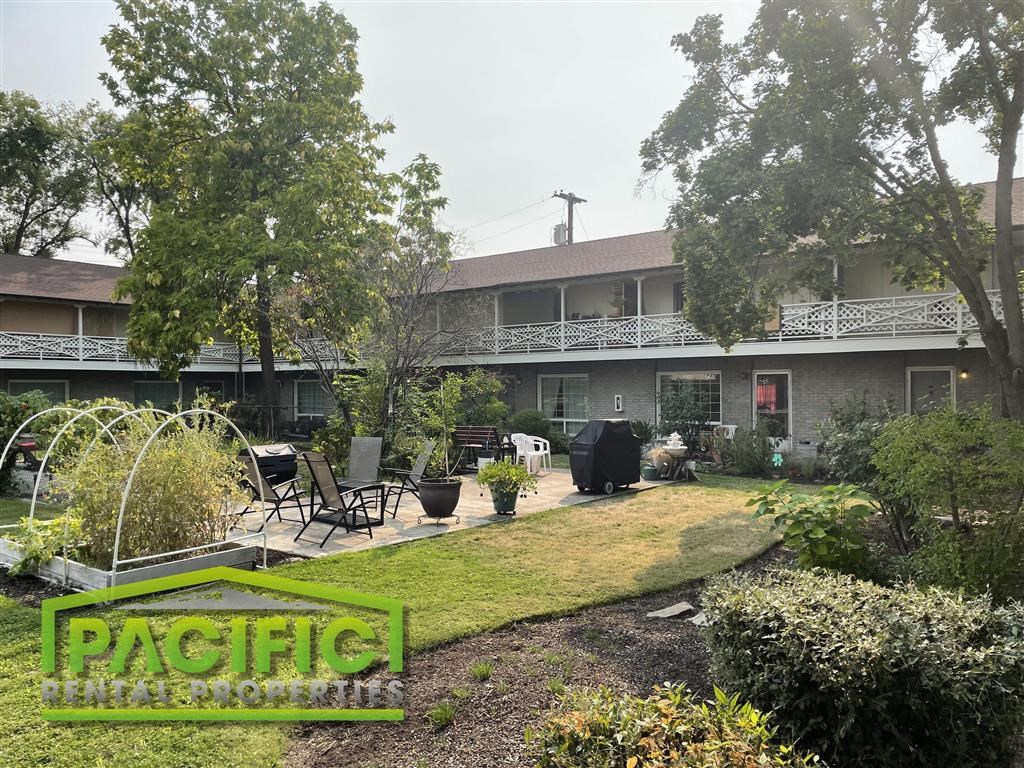 a garden with a patio in front of a house
