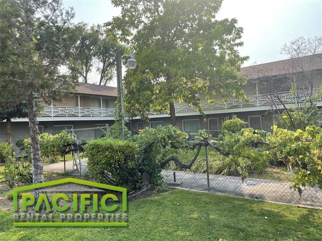 a building with a fence and a sign on the grass