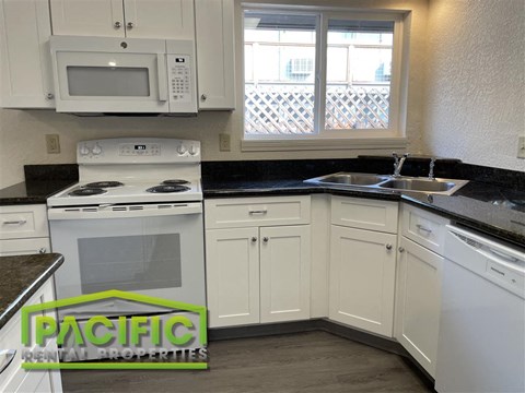 A kitchen with a stove top oven and a microwave above it.