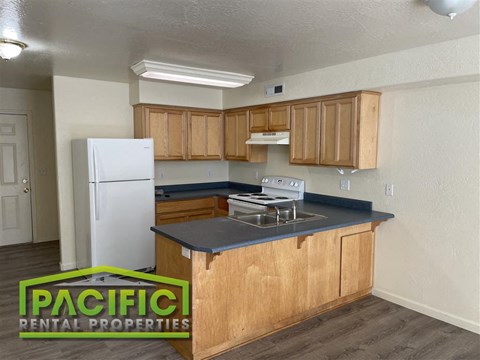 A kitchen with wooden cabinets and a white refrigerator.
