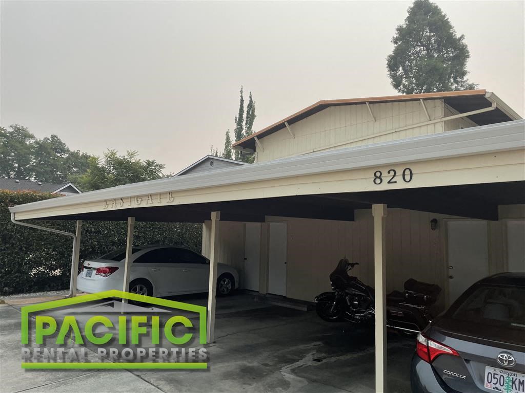 a parking garage with cars and a motorcycle in it