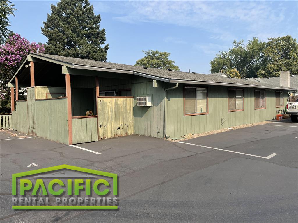 a green building with a parking lot in front of it
