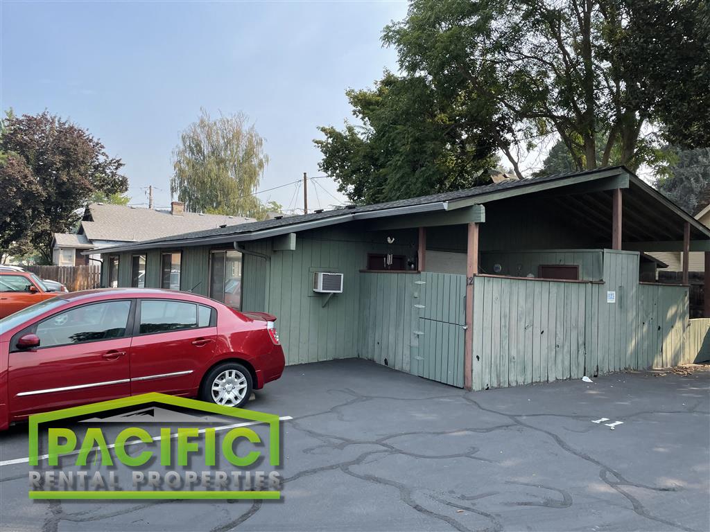 a red car parked in front of a green building
