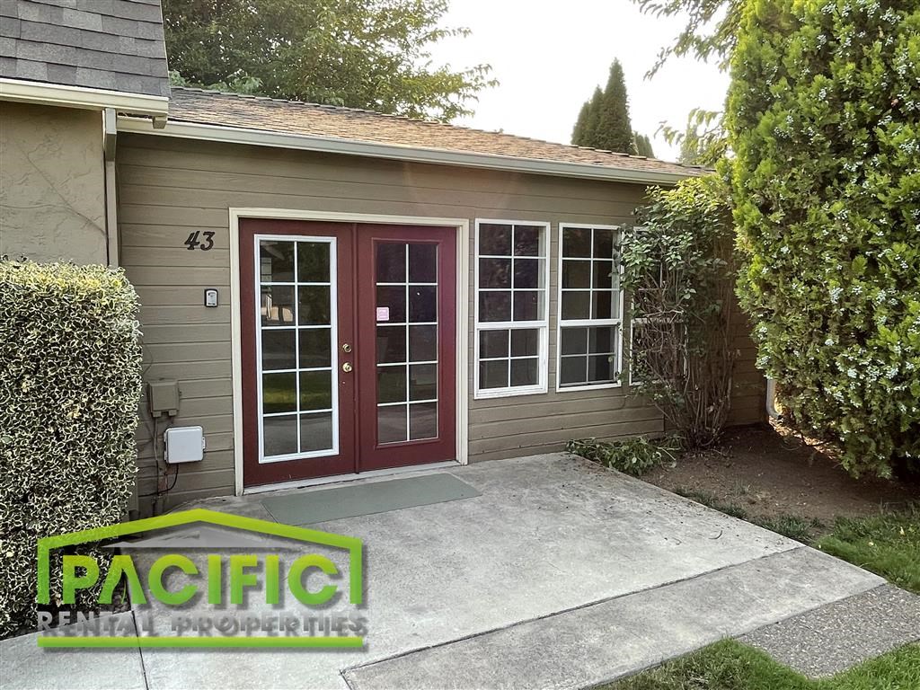 the front of a house with a driveway and a red door