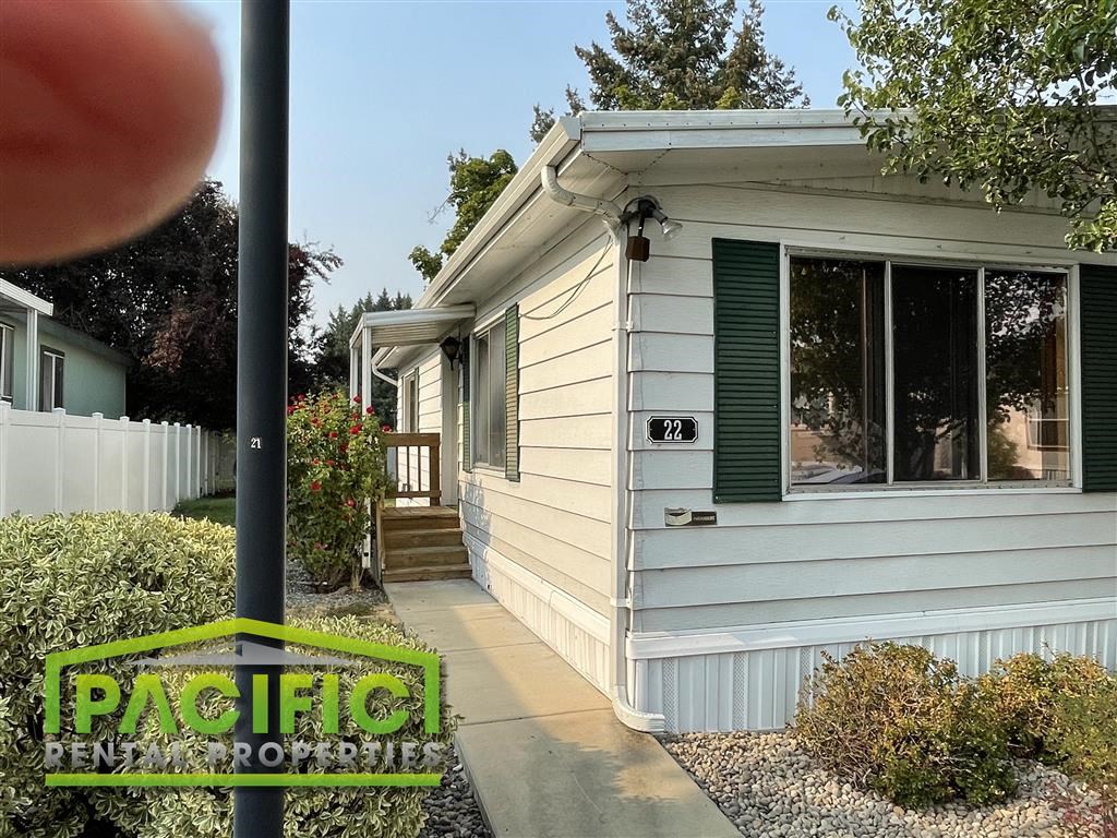 a white house with green shutters and a sidewalk
