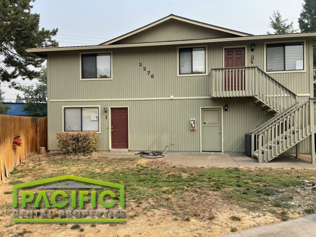 a green house with a porch and a staircase