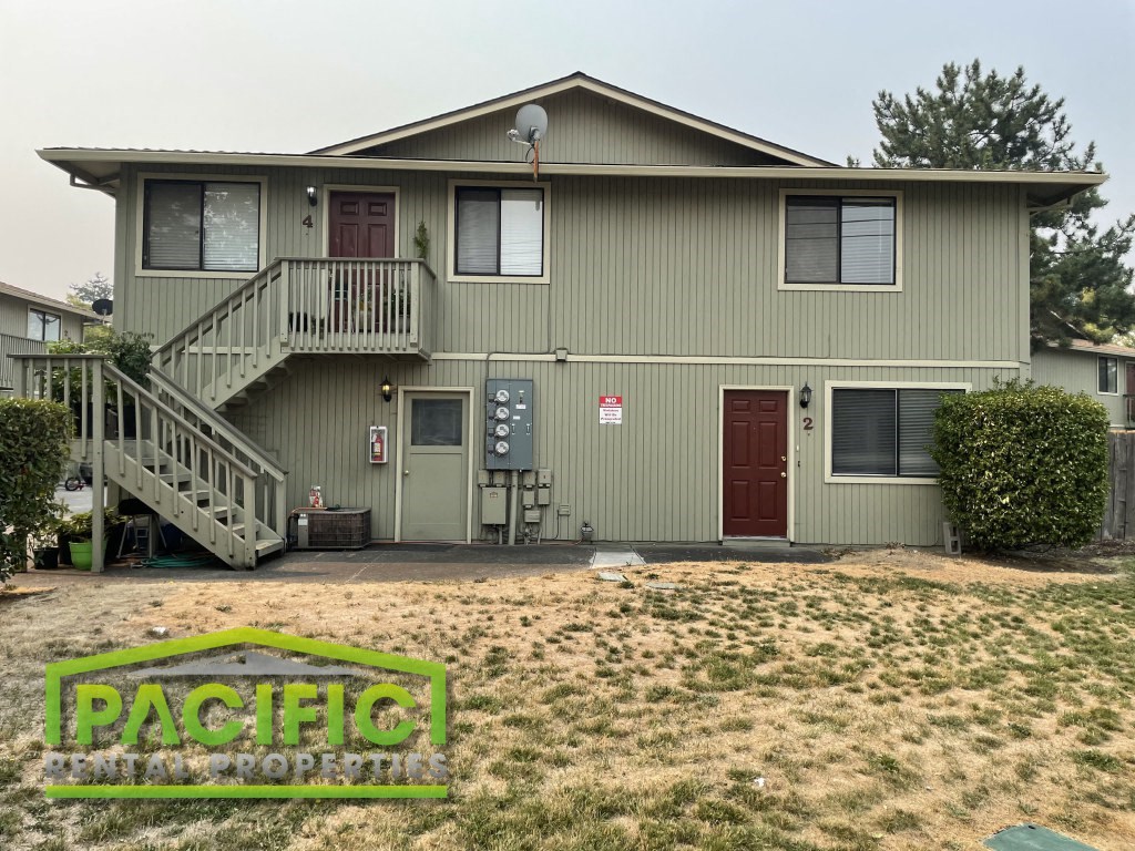 a green house with a front yard and a porch