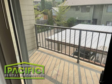 a balcony with a metal railing overlooking a house