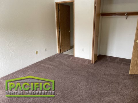 an empty carpeted room with a pacific logo on the carpet