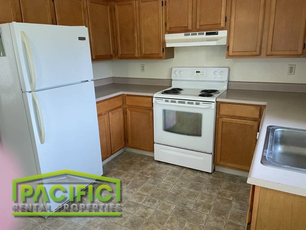 a kitchen with a stove refrigerator and a sink