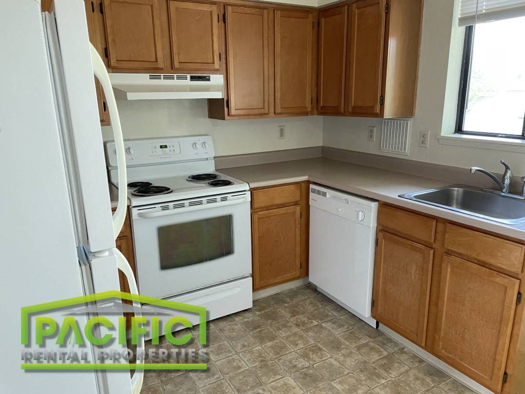 a small kitchen with white appliances and wooden cabinets