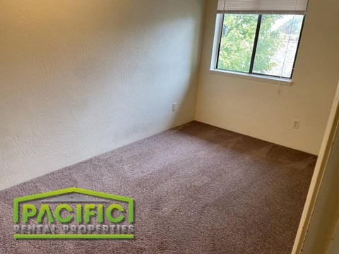 an empty room with a carpeted floor and a window