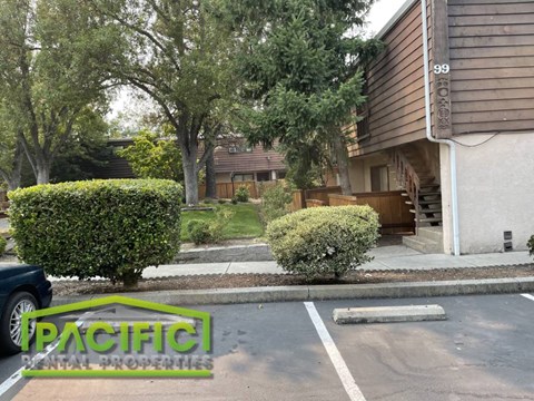 an empty parking lot in front of a house