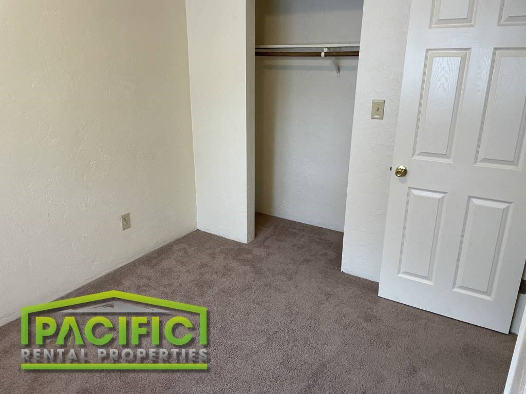 an empty room with a closet and a carpeted floor
