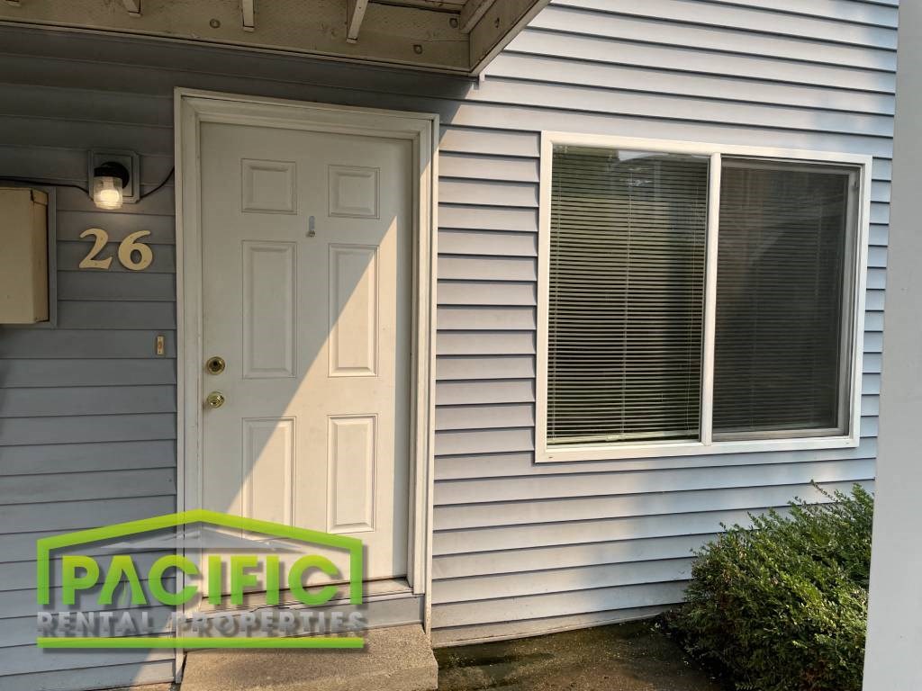 a home with a white door and a window