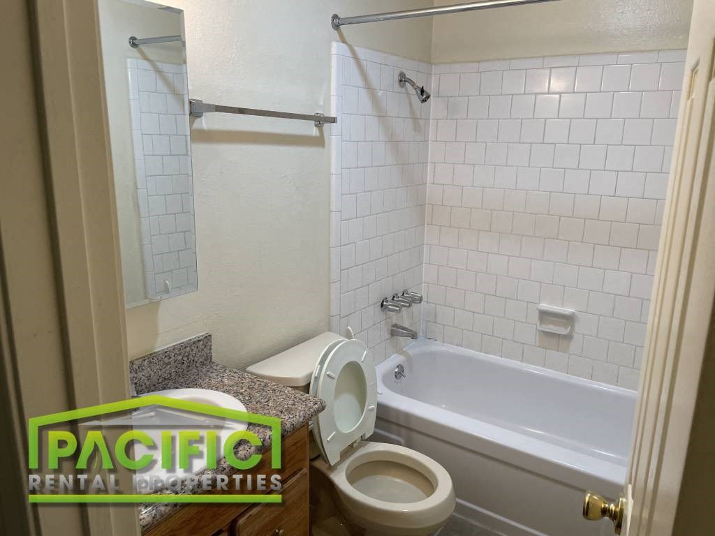 a bathroom with a toilet and a tub and a sink