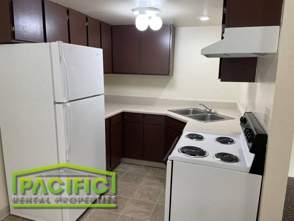 a kitchen with a stove refrigerator and a sink