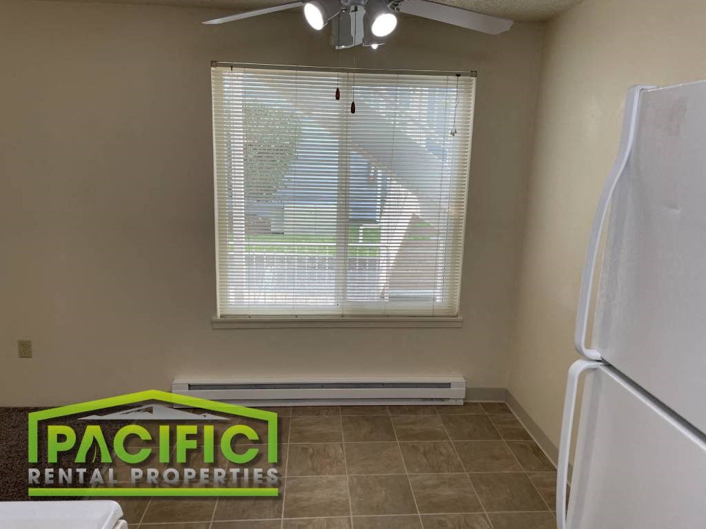 a kitchen with a window and a white refrigerator