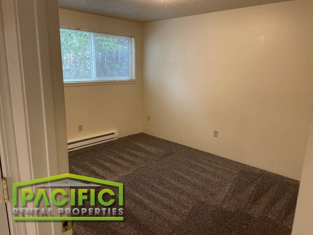 a empty room with carpet and a window