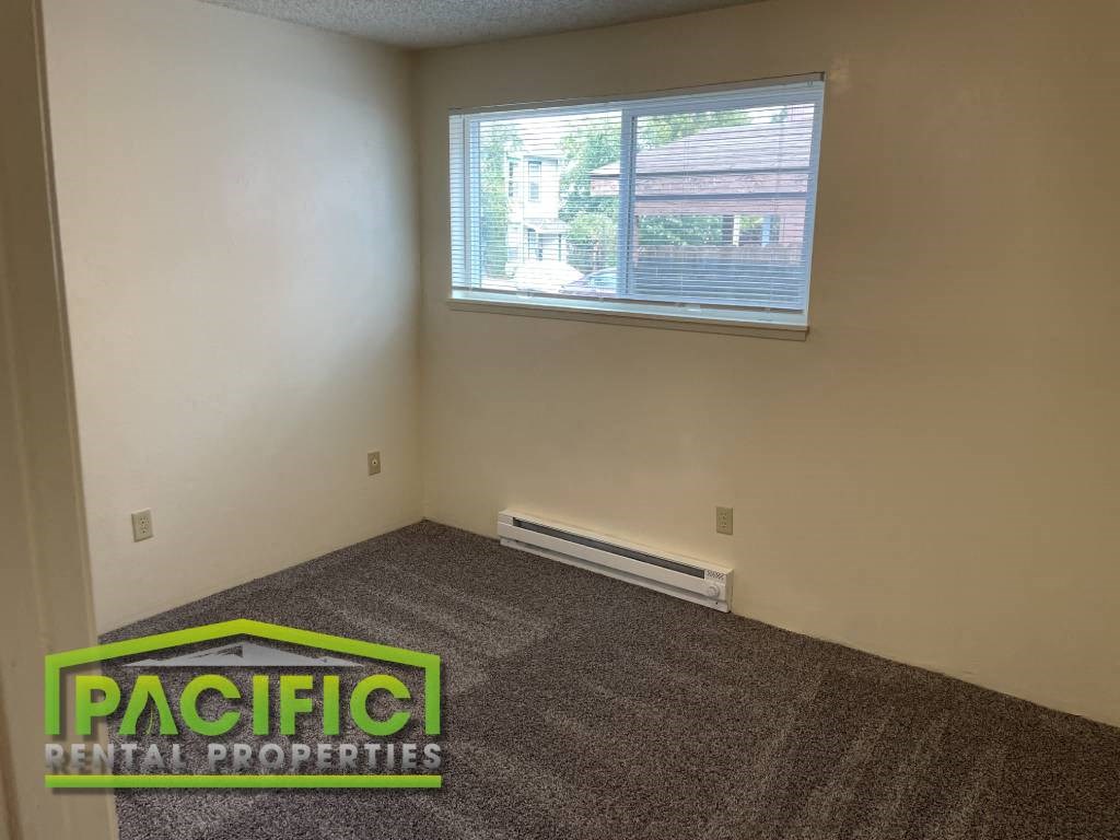 an empty room with a window and carpet