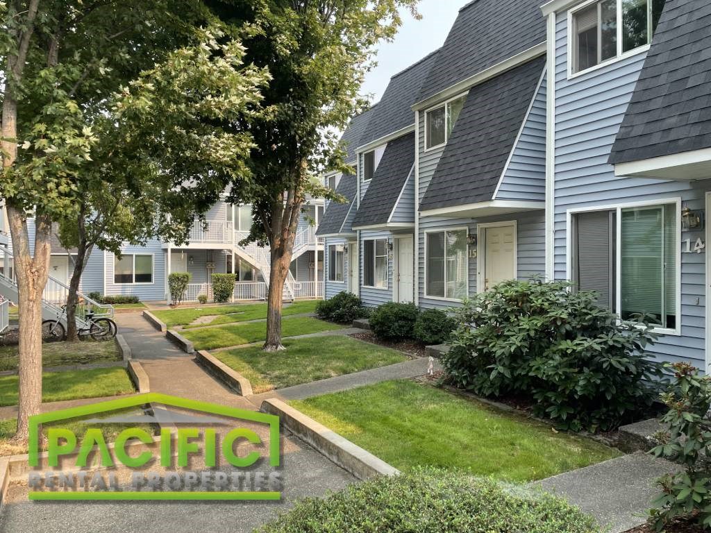 a row of houses in a neighborhood with trees and grass